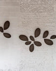 Decorative wall art with leaf-shaped stones on a textured wall by Gardeco available at Spacio retail stores in Mumbai & Kolkata.  