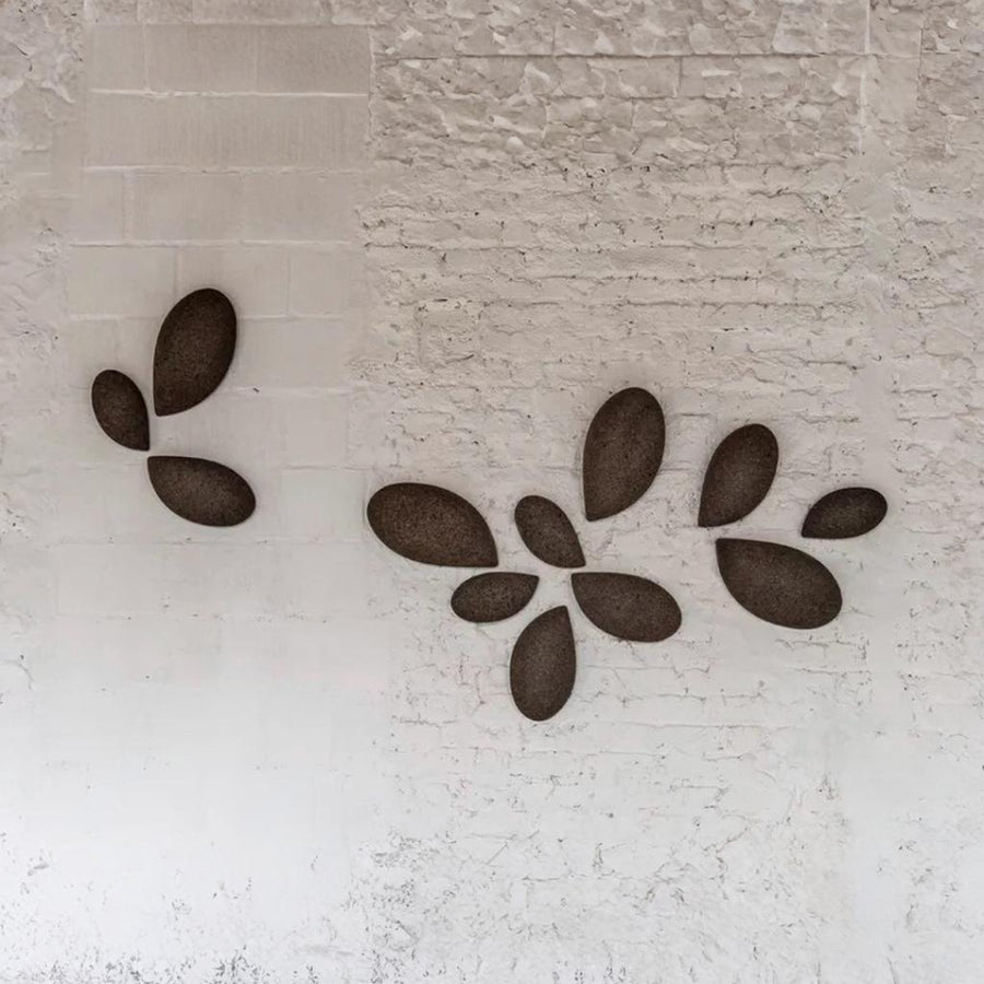 Decorative wall art with leaf-shaped stones on a textured wall by Gardeco available at Spacio retail stores in Mumbai & Kolkata.  