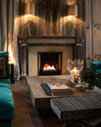 A living room with teal couches and a Planika Bioethanol Fireplace Hot Box.