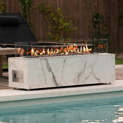 Outdoor setting with lounge chairs and a fire pit by a pool