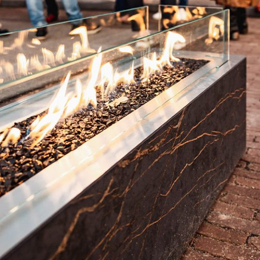 Fire pit on a brick patio with people in the background