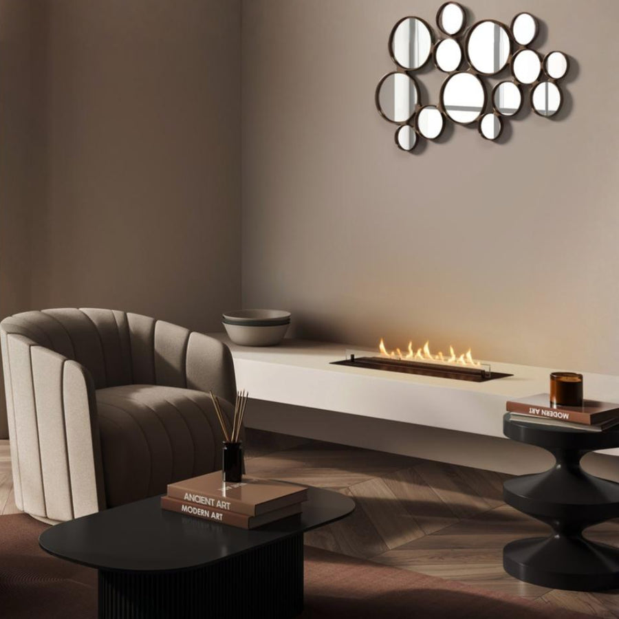 Modern living room with a fireplace, round mirror, and decorative items.