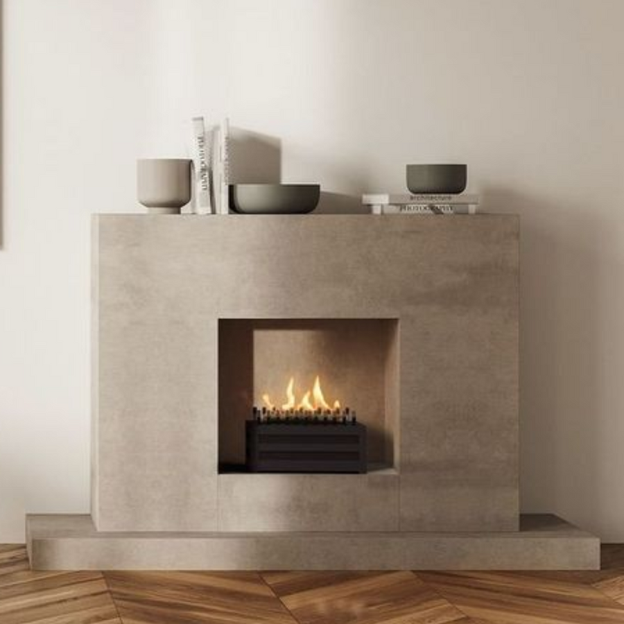 A free standing fireplace with artificial logs from Planika in a modern cement finish fireplace mantle along with some decor accessories styled on the mantle. 
