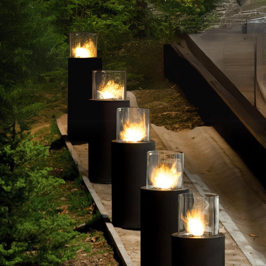 A row of black fireplace totem columns in an outdoor area 