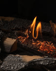 Fireplace with burning wood and flames against a dark background