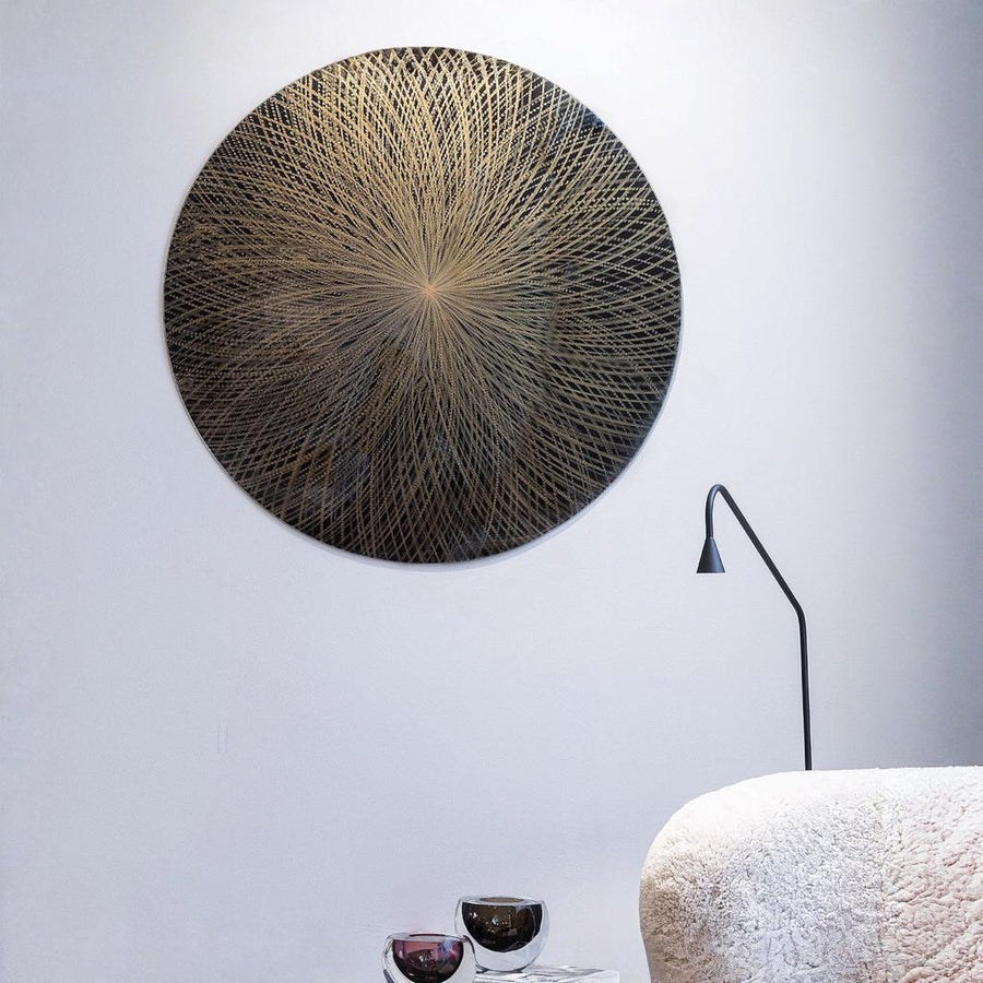 Decorative circular wall art on a white wall with a lamp and textured surface in the foreground  by Gardeco available at Spacio retail stores in Mumbai & Kolkata.  