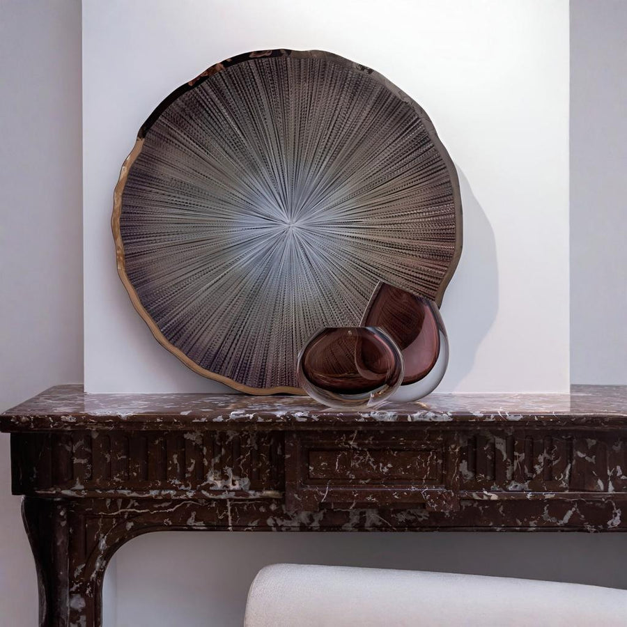 Decorative glass wall art on a wooden table against a white wall by Gardeco available at Spacio retail stores in Mumbai & Kolkata.  