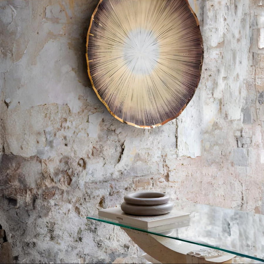 Decorative wall art with sunburst design on a textured stone wall by Gardeco available at Spacio retail stores in Mumbai & Kolkata.  