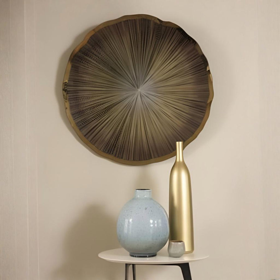 Decorative wall art with a textured design, accompanied by two vases on a small table against a beige wall.