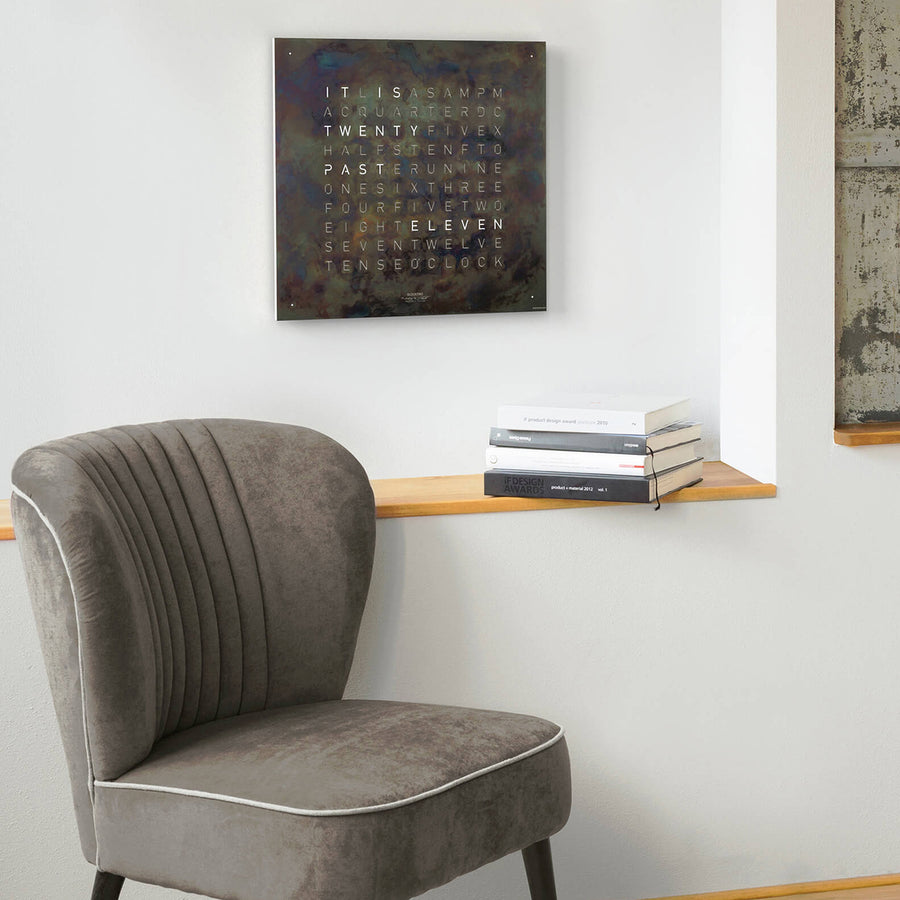 Qlocktwo Earth 45 Creator's Edition Raw Iron Clock on a wall of sitting area with books available at Spacio India for luxury home decor collection of Timepieces & Clocks.