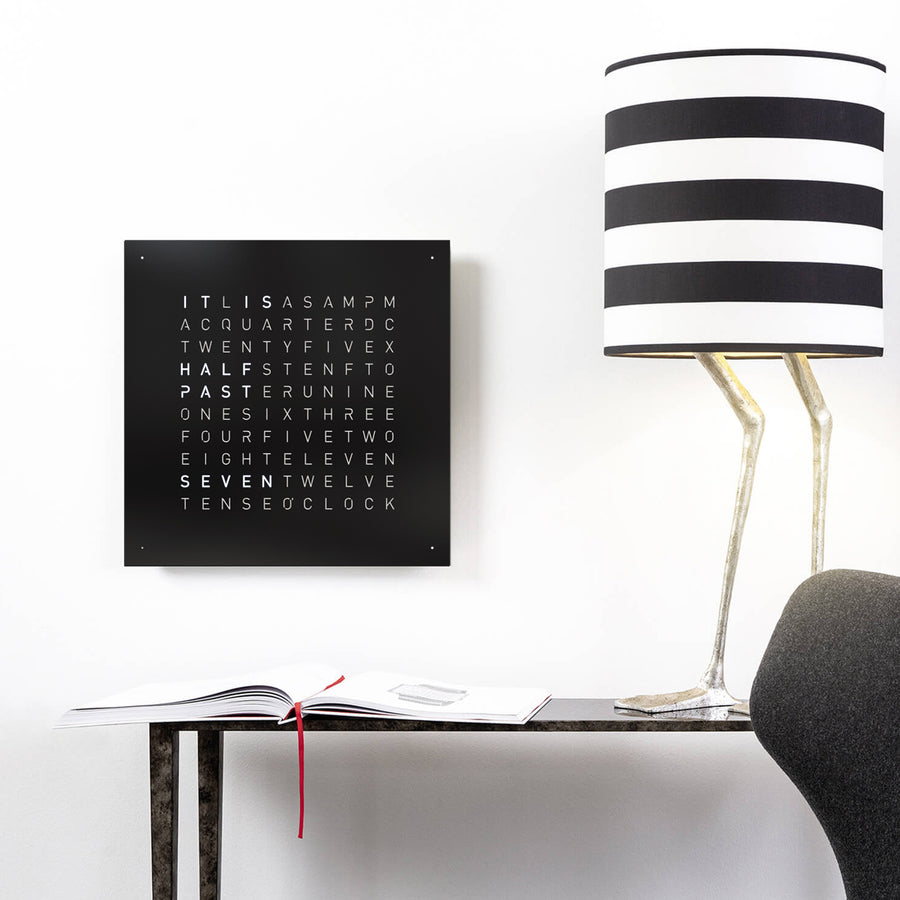 Qlocktwo Earth 45 Steel Black Pepper Clock, paired with a lamp and console table available at Spacio India from our luxury home decor collection for exclusive timepieces and clocks.