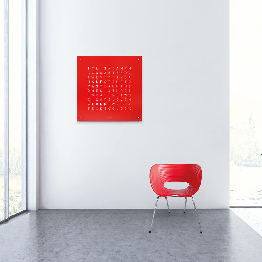 Qlocktwo Earth 90 Steel Red Pepper Limited Edition Clock in a seating area of modern interior with Chair available at Spacio India for luxury home decor collection of Timepieces & Clocks.