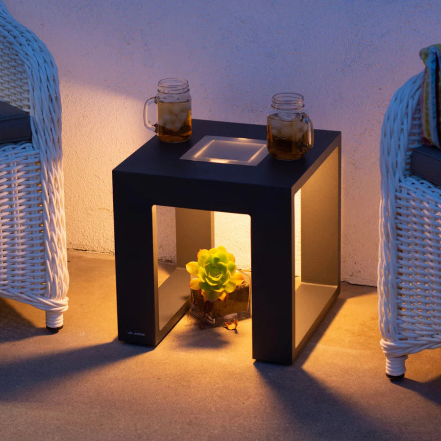 Black side table with a plant and two glasses on a patio with solar light by Les Jardins available at Spacio retail stores in Mumbai & Kolkata. 