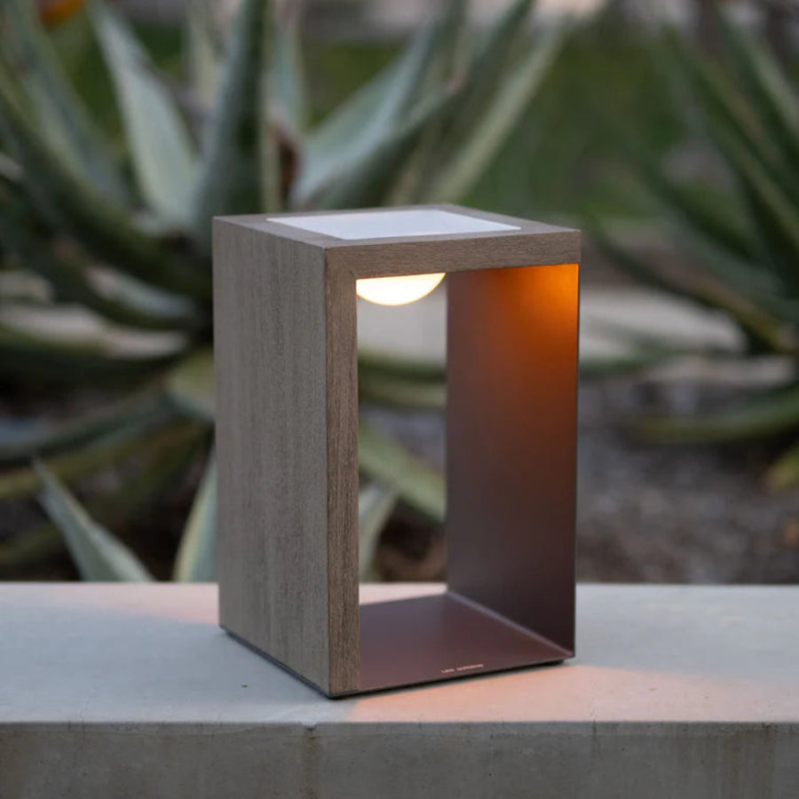Modern outdoor indoor solar light lantern on a concrete surface with plants in the background by Les Jardins available at Spacio retail stores in India.