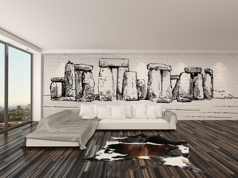 Hand-drawn fresco artwork of Stonehenge, handcrafted in Italy on plaster sheets with Carrara marble and Roman travertine powder, part of Spacio's Luxury Art Surface collection in a luxury living room with wooden flooring and sofa