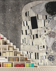 A fresco mural of Gustav Klimt’s The Kiss in subtle monochromatic tones, featuring an intricate blend of patterns and crafted with Italian plaster for a luxurious finish. Featured on a wall behind a wooden staircase book shelf