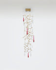 Decorative hanging wall lamp with gold branches and red accents on a white background