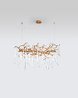 A Serip Aqua Chandelier, a nature-inspired gold chandelier with crystal drops hanging from it.