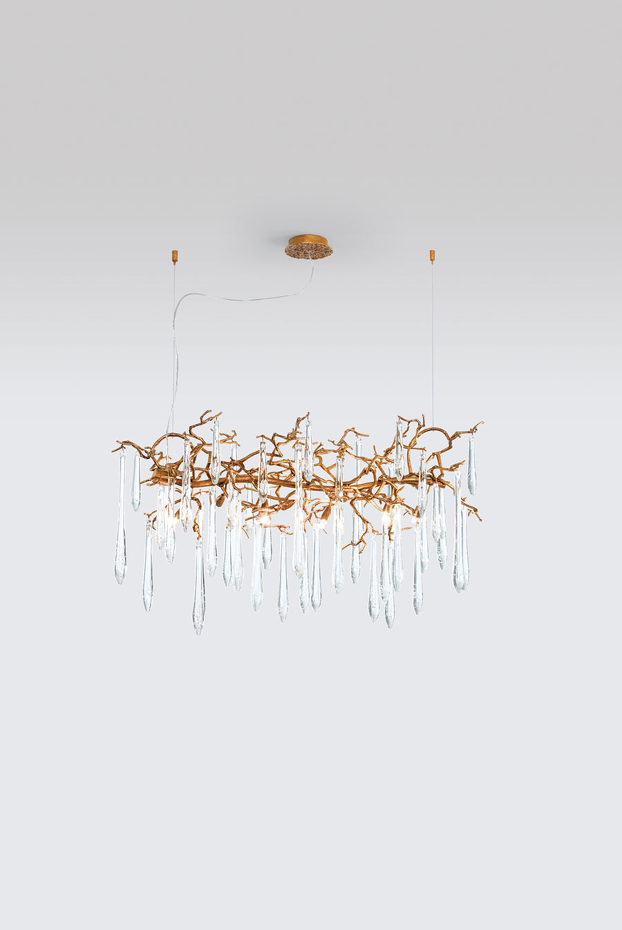 A Serip Aqua Chandelier, a nature-inspired gold chandelier with crystal drops hanging from it.