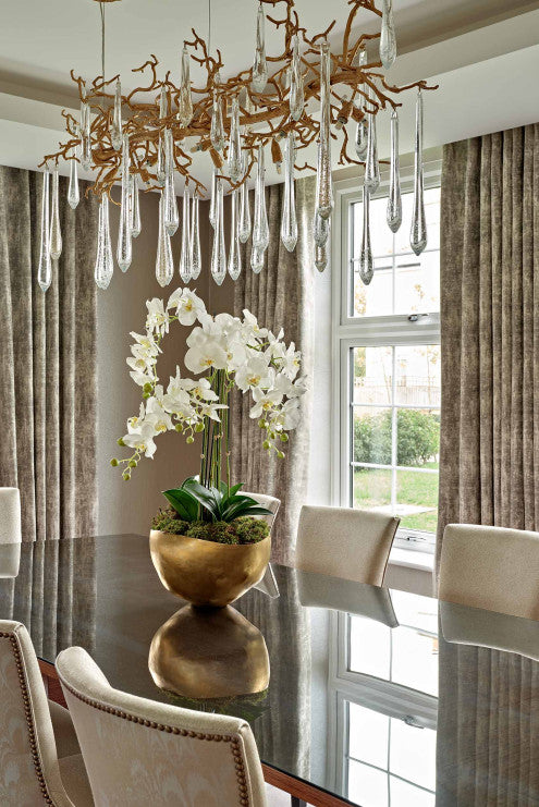 A dining room with a nature-inspired Serip Aqua Chandelier from Serip hanging over the table.