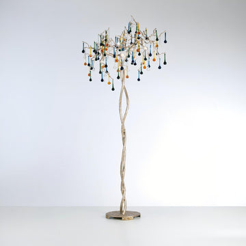 A floor lamp with glass droplets hanging from golden branch on a light grey colour background