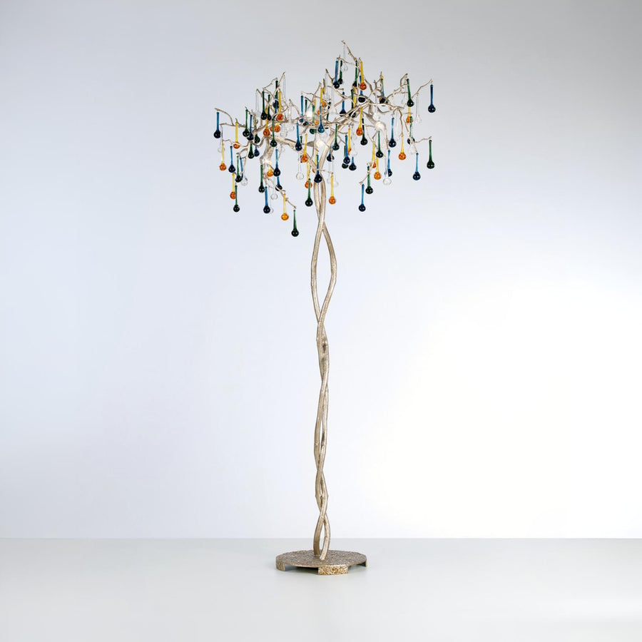 A floor lamp with glass droplets hanging from golden branch on a light grey colour background