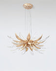 A flower shaped chandelier suspending from the ceiling on a light grey colour background. 
