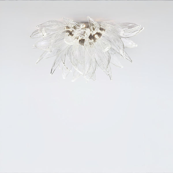 A flower shaped ceiling light in glass and metal fixed on the ceiling on alight grey colour background