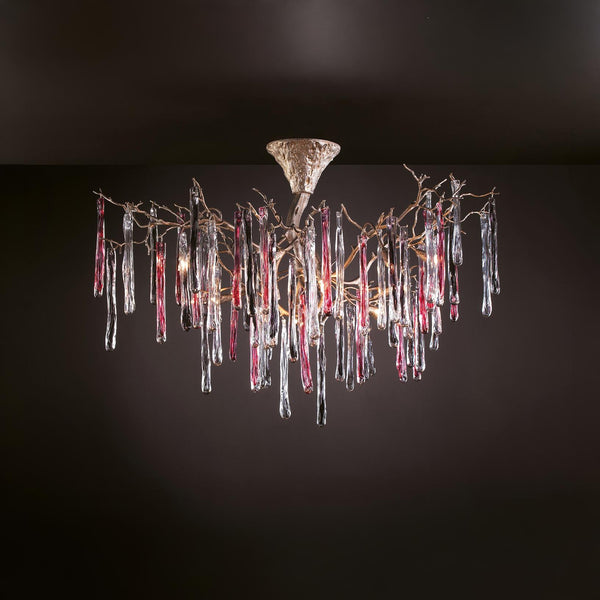 A colourful chandelier suspended from a ceiling with colourful glass icicles hanging from golden colour branches on a dark grey background.