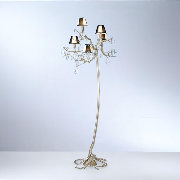 An ornate floor lamp with falling droplets shaped glass and small shades on a grey colour back ground. 
