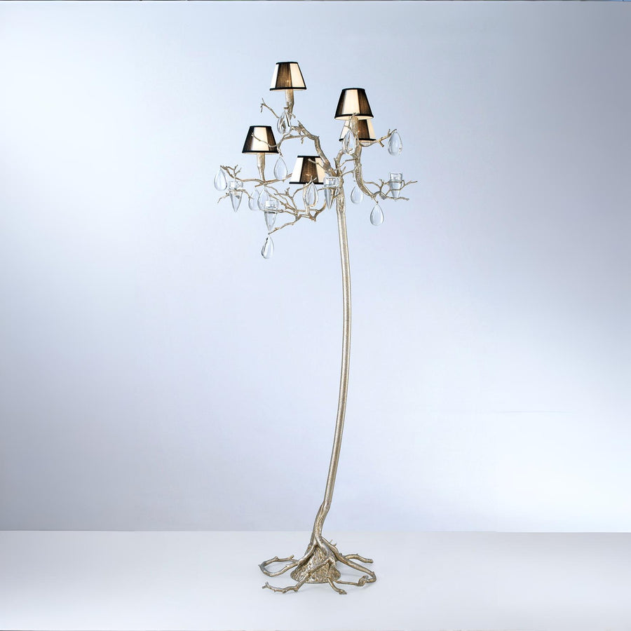 An ornate floor lamp with falling droplets shaped glass and small shades on a grey colour back ground. 