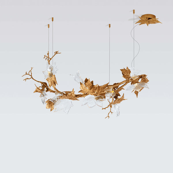 Decorative chandelier with gold leaf design on a light gray background from Serip available at Spacio
