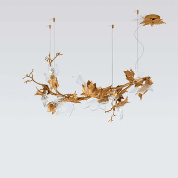 Decorative chandelier with gold leaf design on a light gray background from Serip available at Spacio