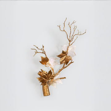 Decorative wall sconce with gold branches and leaves on a light blue background