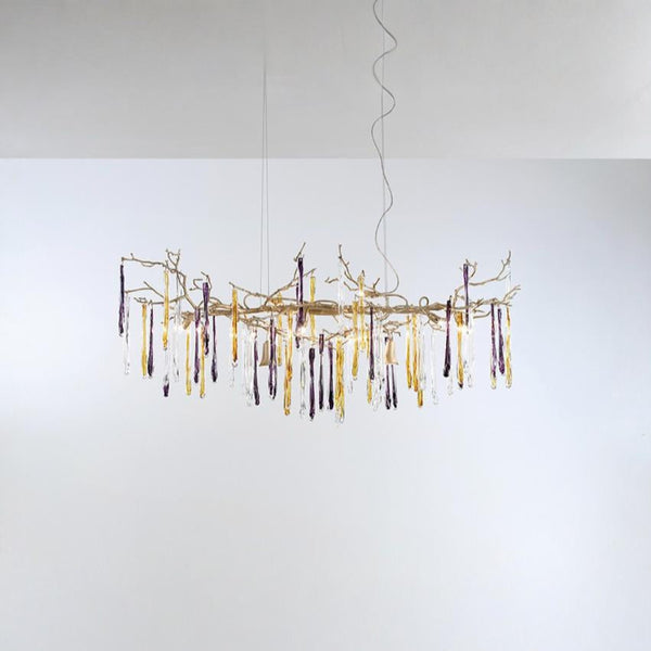 A chandelier hanging from the ceiling with colourful icicles shape glass on a light grey colour background
