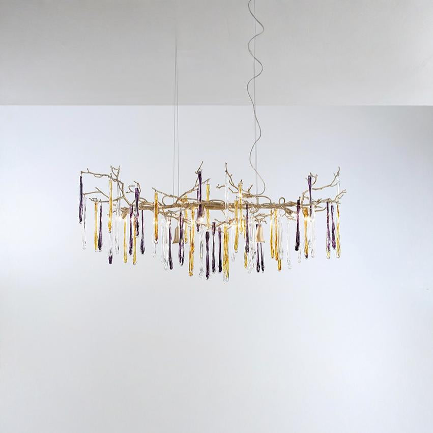 A chandelier hanging from the ceiling with colourful icicles shape glass on a light grey colour background