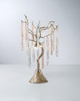 A table lamp with colour glass icicles hanging from golden colour branches on a light grey colour background