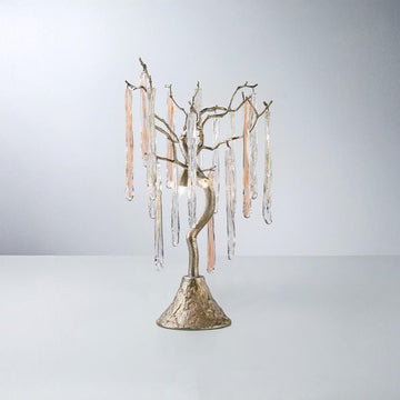 A table lamp with colour glass icicles hanging from golden colour branches on a light grey colour background