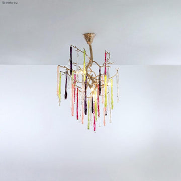 A colourful chandelier suspended from a ceiling with colourful glass icicles hanging from golden colour branches on a light grey background.