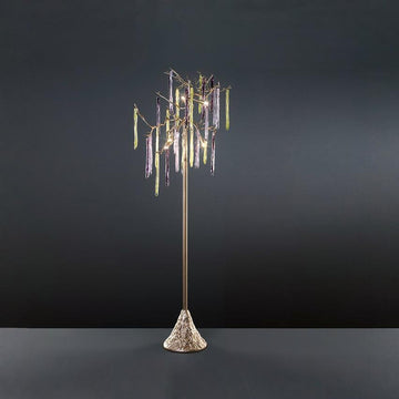 A floor lamp with colourful glass icicles hanging from metal branches on a grey background