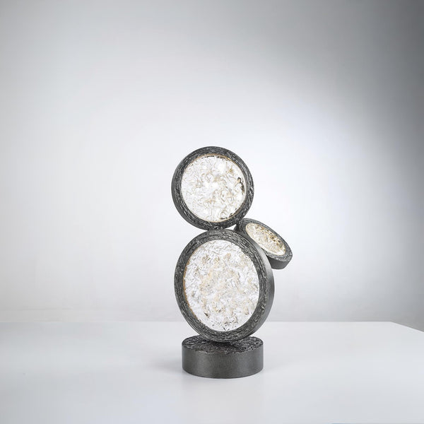 Decorative table lamp with circular design on a white surface and gray background