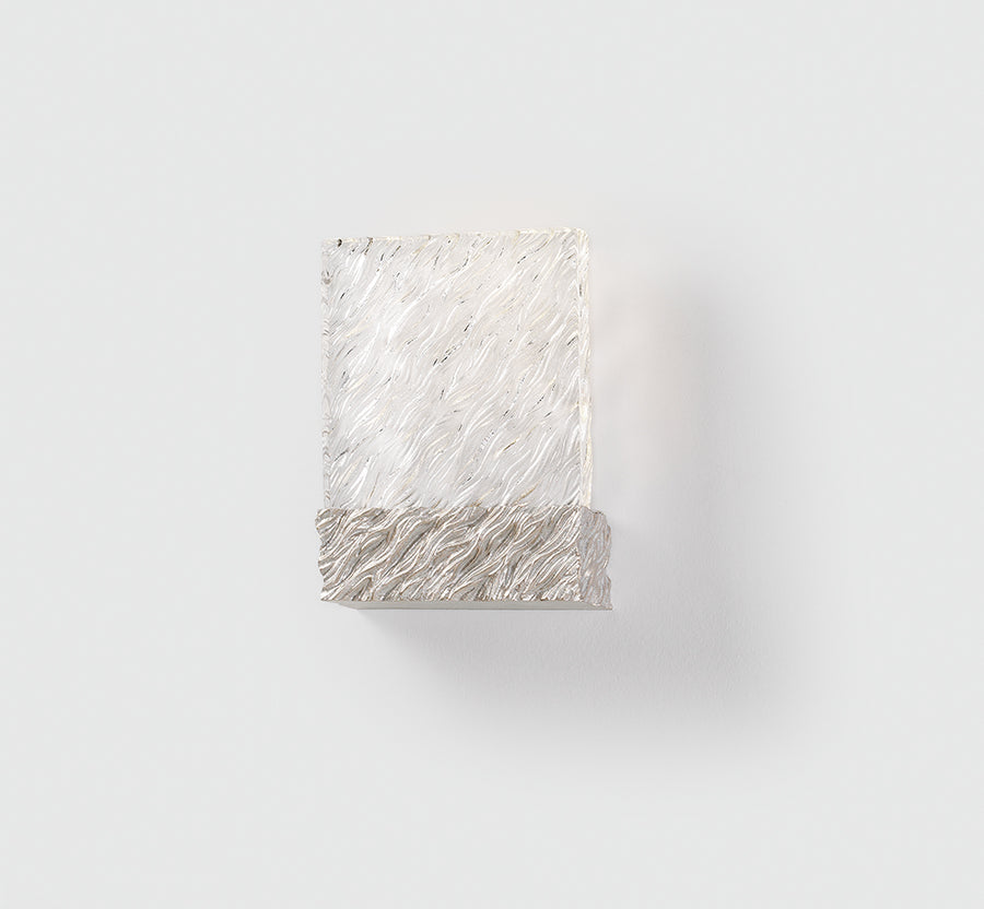 Decorative wall light with wavy texture on a white background