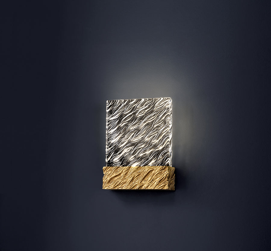 Decorative wall sconce with wavy design on a dark background