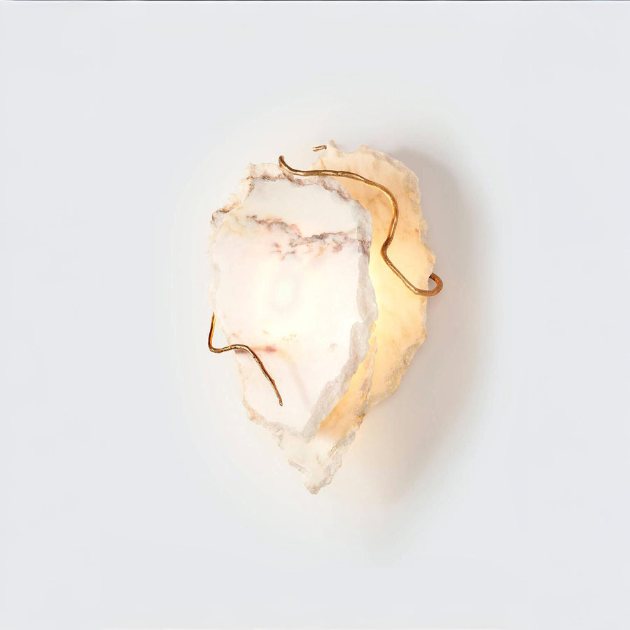 Decorative wall sconce with marble and gold finish on a white background
