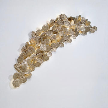 Decorative wall light fixture with leaf-like design on a white background