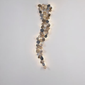 Decorative wall light with leaf-like design on a plain wall