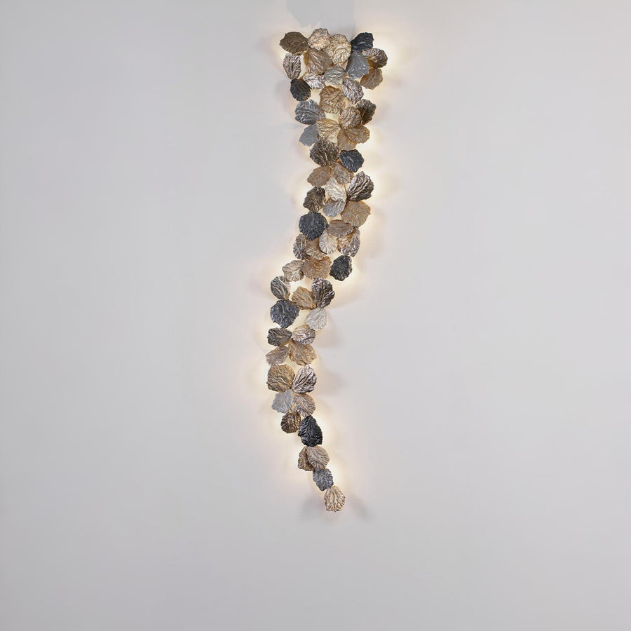 Decorative wall light with leaf-like design on a plain wall