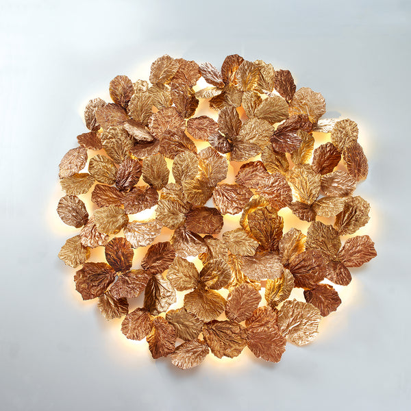 Decorative wall light fixture with leaf-like design on a white background