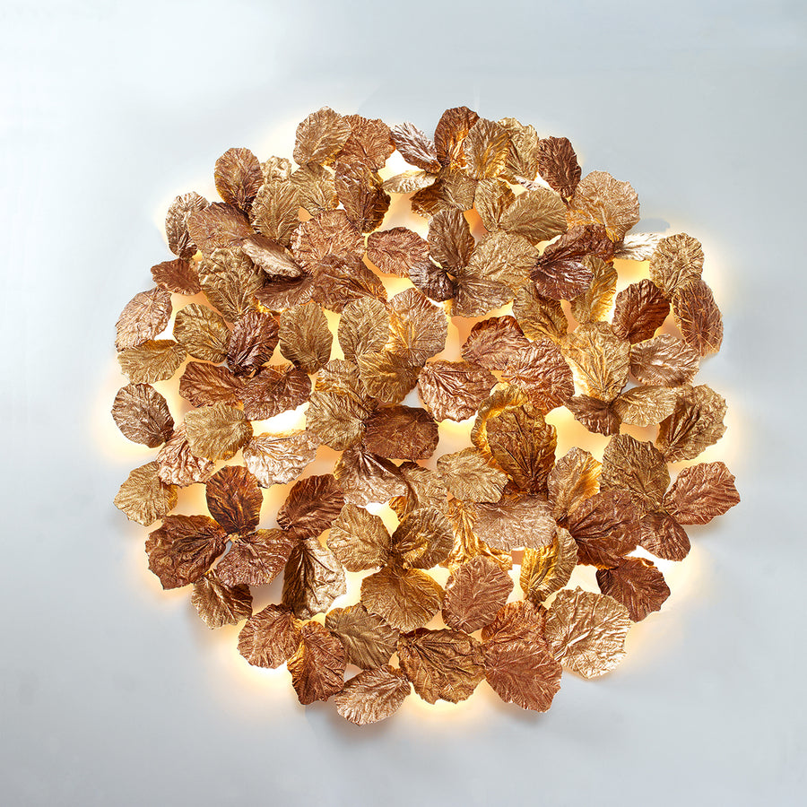 Decorative wall light fixture with leaf-like design on a white background