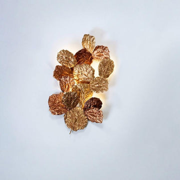 Decorative wall light with leaf design on a white background